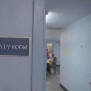 A sign indicating the 'Hospitality Room' in a hallway.