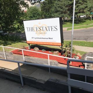 A community sign for 'The Estates' displayed in an outdoor setting.