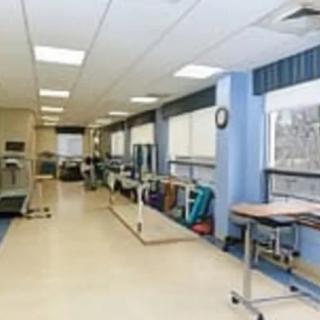 A well-equipped rehabilitation therapy room with parallel bars and exercise gear.