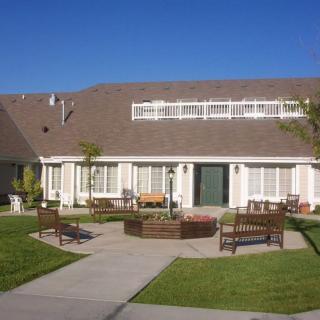 A suburban house with a neatly maintained yard and outdoor seating.