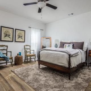 A cozy bedroom with a stylish interior design featuring a comfortable bed, wooden flooring, and elegant decor.