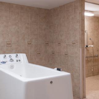 A modern bathroom featuring a sleek bathtub and tiled walls.