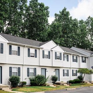 A row of suburban townhouses surrounded by trees.