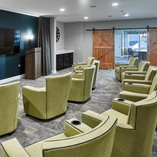 A modern theater room with comfortable seating and a large television.