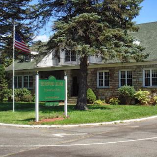A well-maintained building with a flag in front, surrounded by lush landscaping.