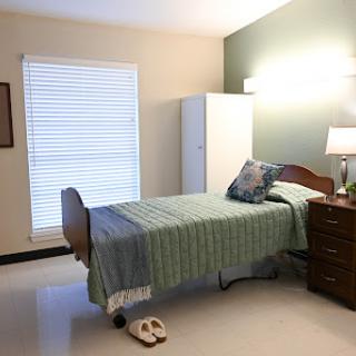 A cozy and well-arranged bedroom featuring a bed, dresser, and natural light.