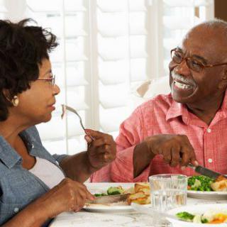 A couple enjoying a meal together at home, engaged in pleasant conversation.