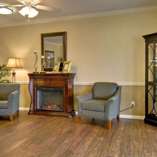 A cozy living room with a fireplace, armchairs, and elegant decor.