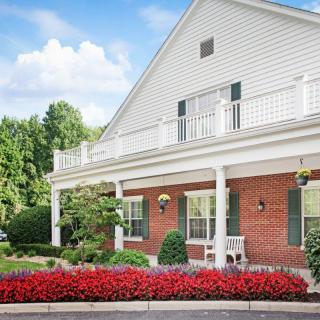 A charming house with a brick facade and beautiful landscaping.