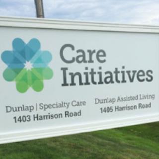 A sign for Care Initiatives located on Harrison Road, offering Dunlap Specialty Care and Assisted Living services.