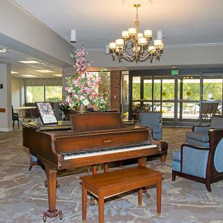 A cozy lobby featuring a grand piano, comfortable seating, and elegant decor.