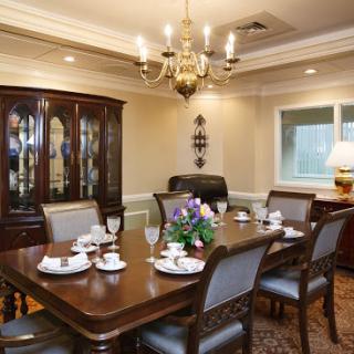 An elegant dining room ready for a formal gathering, featuring a beautifully set table and classic decor.