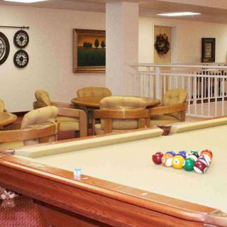A cozy lounge area featuring a billiards table and comfortable seating arrangements.