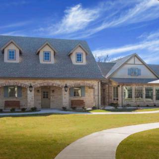 A beautiful suburban house with a well-manicured lawn and a clear blue sky.