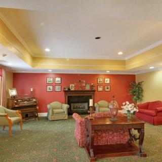 A cozy living room with a traditional decor featuring warm colors and comfortable seating around a fireplace.