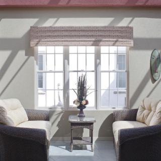A bright living room with two sofas facing each other, a small coffee table in between, and sunlight streaming through a large window.
