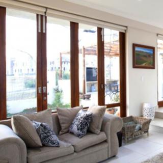 A bright living room with a comfortable sofa and large windows allowing abundant sunlight.