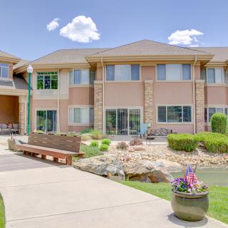 A two-story residential building with landscaped surroundings on a sunny day.