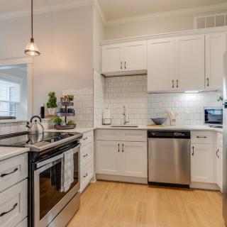 A modern kitchen with white cabinets, stainless steel appliances, and a subway tile backsplash.