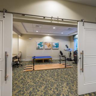 A physical therapy room equipped with exercise equipment and parallel bars.