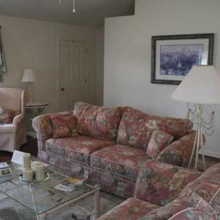 A cozy living room with floral-patterned furniture and decor.
