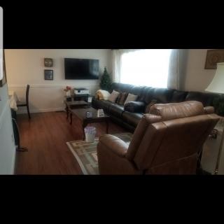 A cozy living room with leather furniture and a mounted TV.