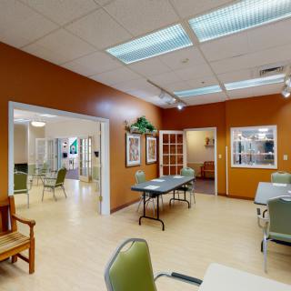 A spacious interior with tables and chairs, featuring warm lighting and decor.