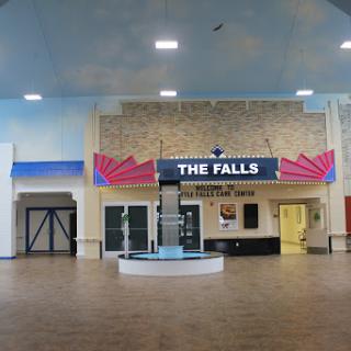 The lobby area of 'The Falls' theater, showcasing a spacious interior with prominent signage.