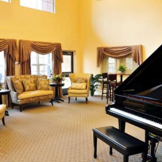 A spacious living room featuring a grand piano, elegant furniture, and tasteful decor.