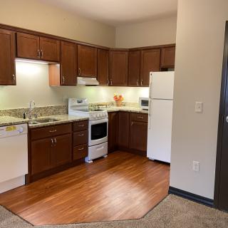 Modern kitchen with wooden cabinets and appliances in an apartment.
