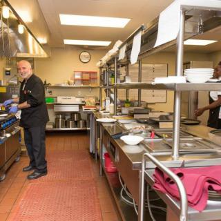 Chefs working in a busy commercial kitchen preparing food.