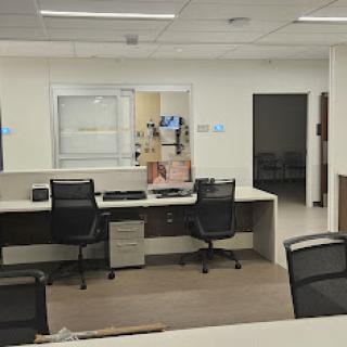 A clean and modern office workspace featuring desks and chairs designed for an administrative area.