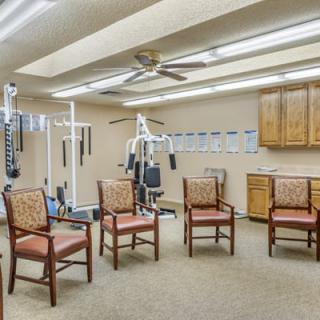 A small exercise room with gym equipment and seating area.