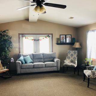 A cozy living room with a sofa, armchair, and various decorations.