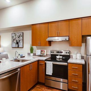A modern kitchen with wooden cabinets and stainless steel appliances.