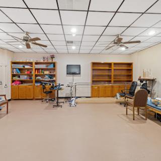 A spacious and well-lit interior featuring shelving units, a workspace, and comfortable seating arrangements.