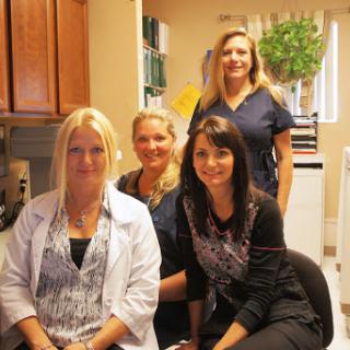 A team of healthcare professionals posing together in an office setting.