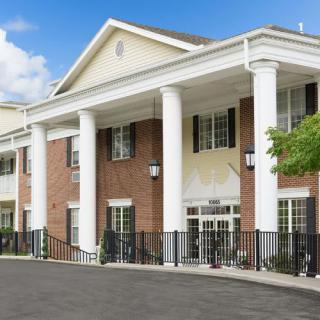 A residential building with a brick facade and large white columns at the entrance.