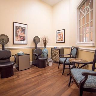 A cozy waiting room with elegant chairs, artwork on the walls, and a calming atmosphere.