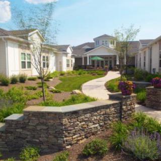 A beautifully landscaped pathway leading to a residential building.