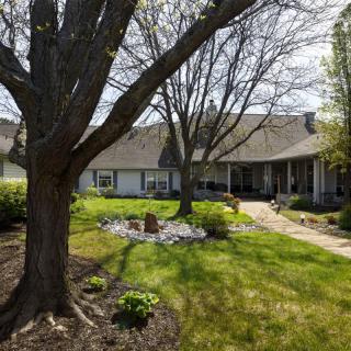 A residential house surrounded by a well-maintained yard and trees in spring.