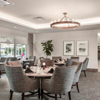 A modern and elegant dining room with stylish seating and a chandelier.