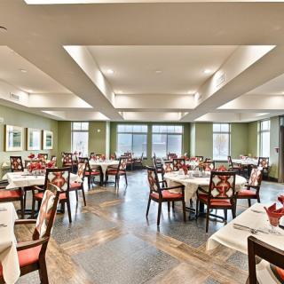 A spacious and elegantly designed dining room with neatly arranged tables and chairs.