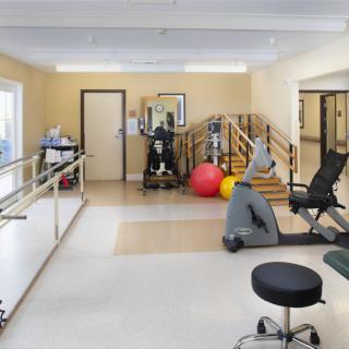 A physical therapy room equipped with exercise machines and rehabilitation tools.