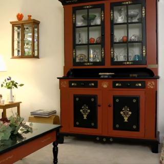 An antique cabinet with glass doors displayed in a well-decorated living room.