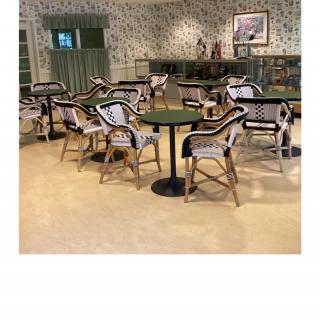 An empty restaurant seating area with bistro-style tables and chairs.