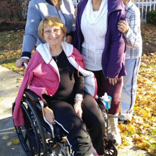 A group of four women enjoying a sunny autumn day, with one woman in a wheelchair.