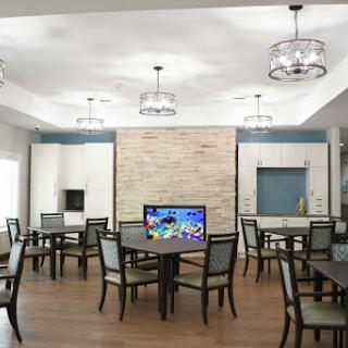 A modern dining room featuring elegant furniture, ample lighting, and a television.