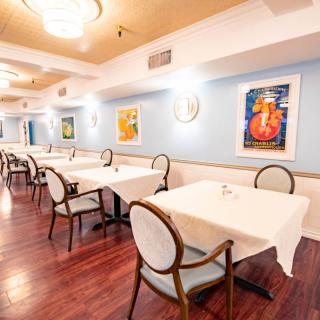 An elegant restaurant interior with neatly arranged tables and decorative artwork on the walls.
