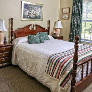 A cozy and traditional bedroom with wooden furniture and decorative elements.